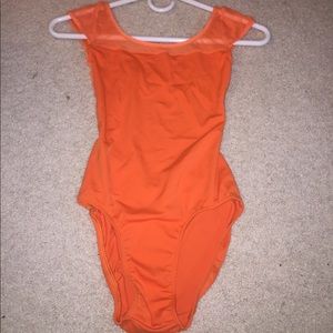 Class In size small orange leotard.